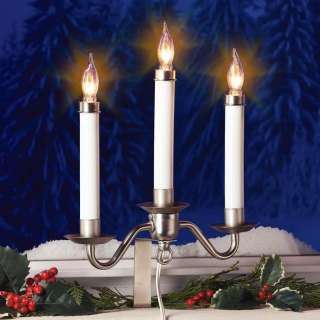 Traditional electric window candelabra casts a bright glow as it 